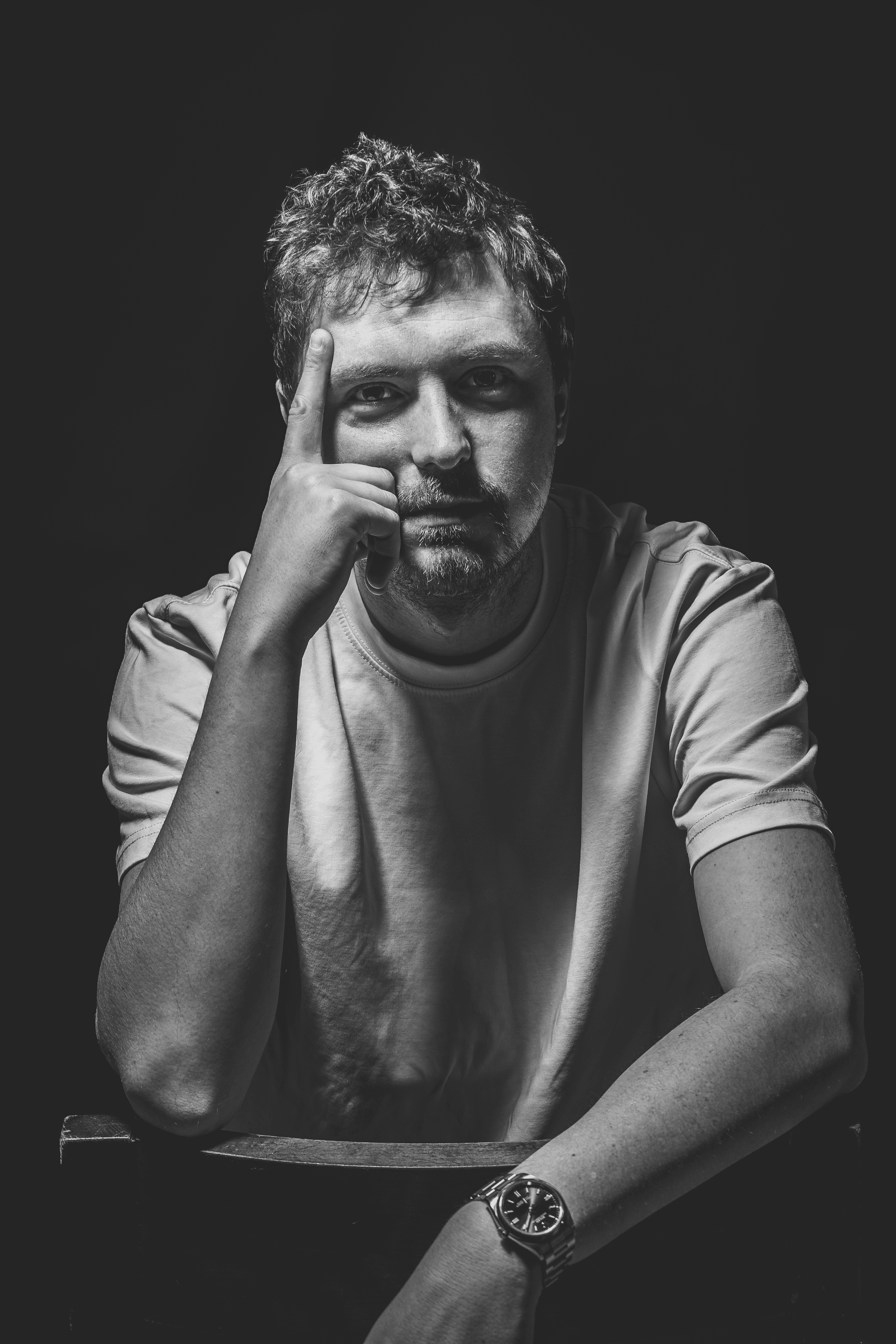 Portrait noir et blanc d'un homme la tête posée sur la main, regard pensif