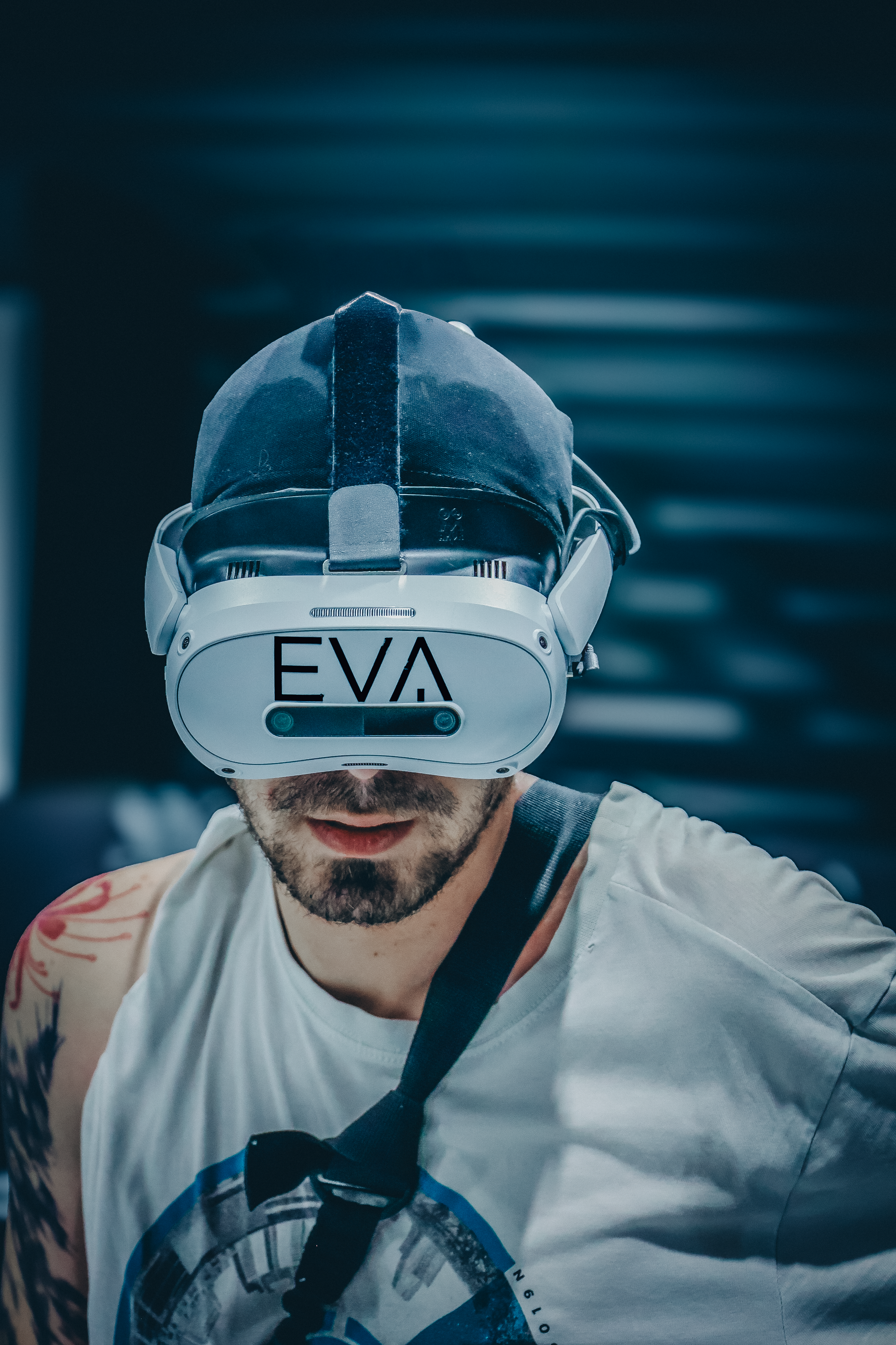 Portrait de face d'un joueur casque de réalité virtuelle, débardeur blanc, avant-bras tatoué