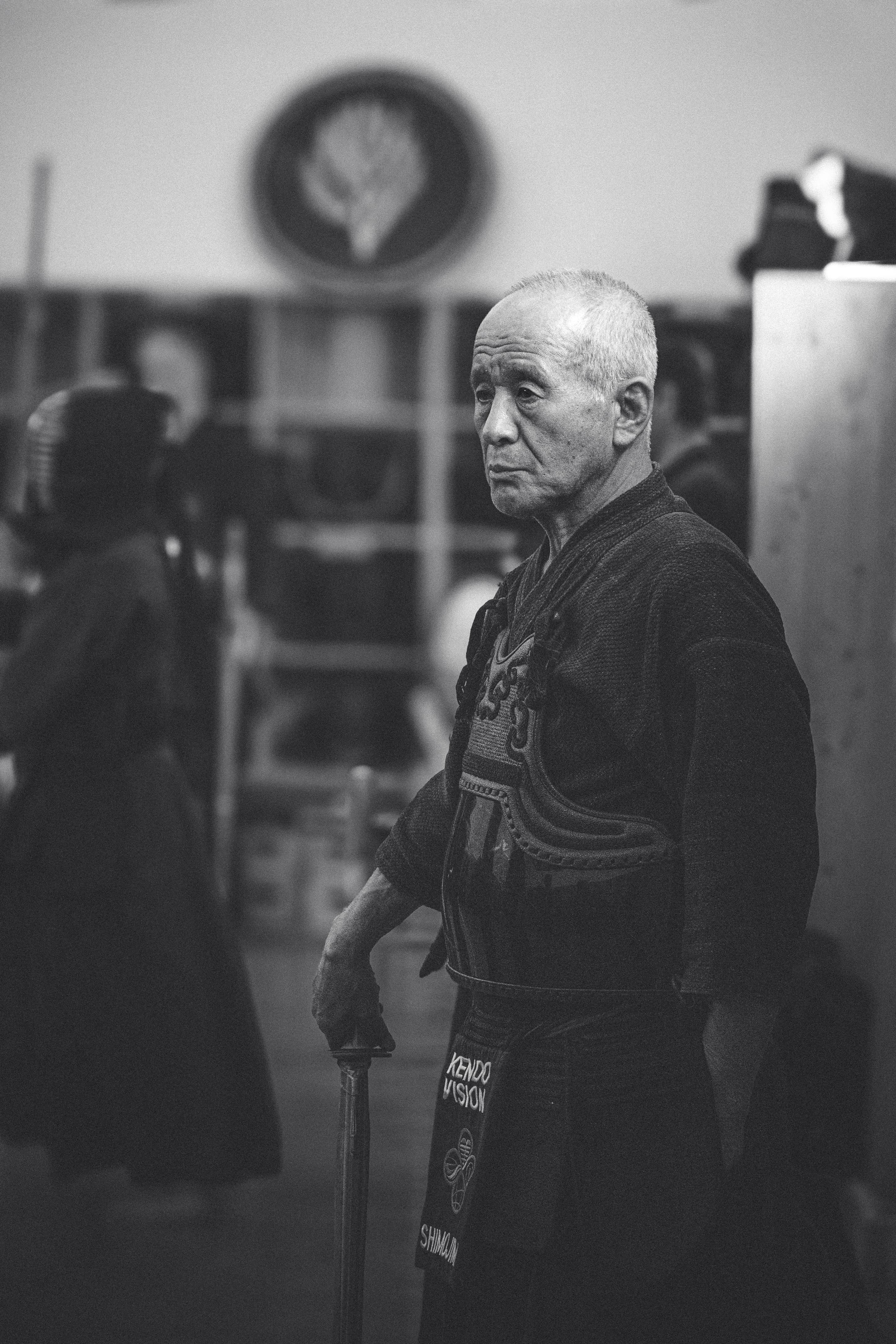Portrait noir et blanc d'un maître de kendo senior en armure, dojo traditionnel