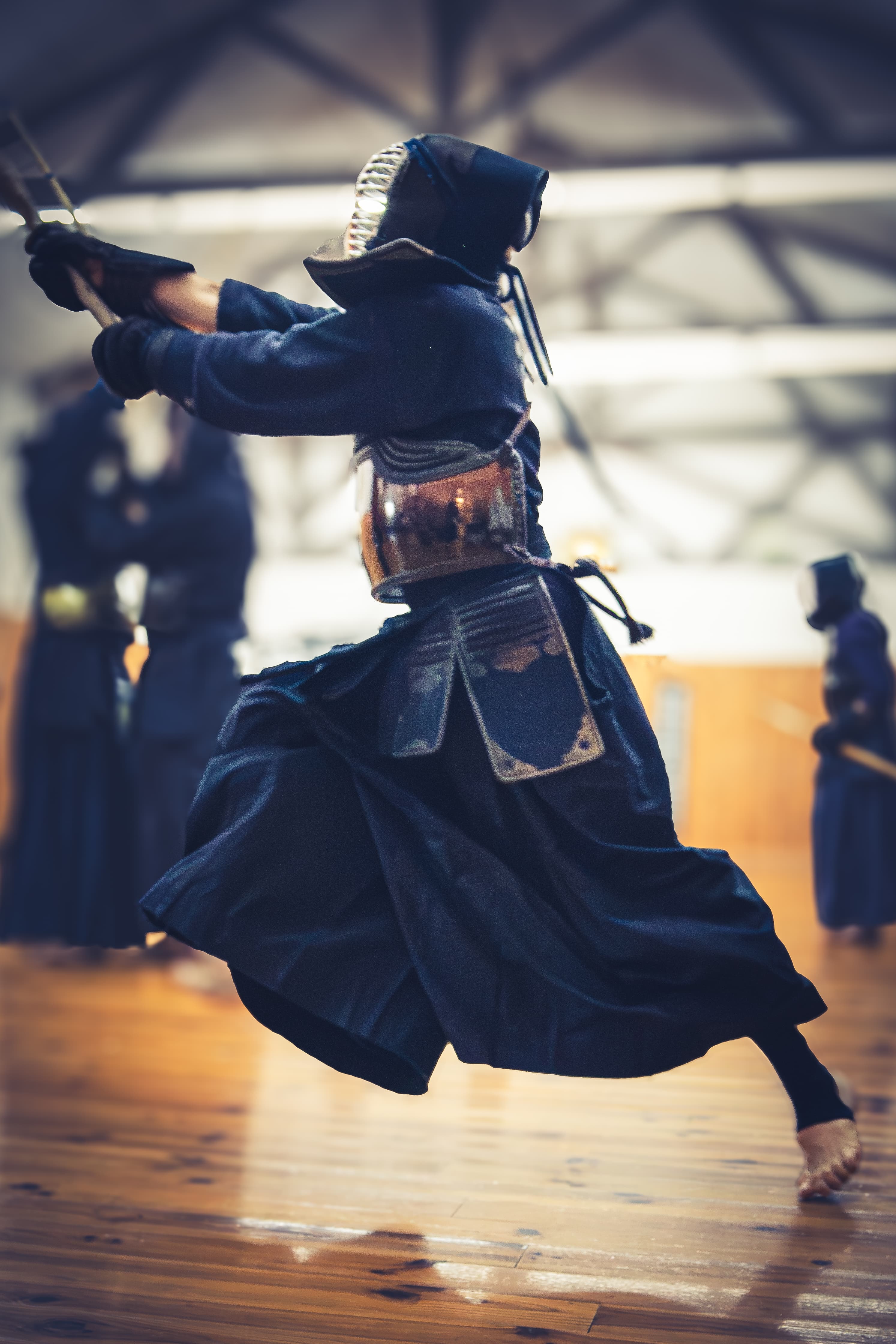 Kendoka en plein assaut, saut et frappe au shinai captés en pleine action